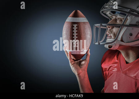 Zusammengesetztes Bild des Sportlers nachschlagen, US-amerikanischer american-Football mit gedrückter Stockfoto