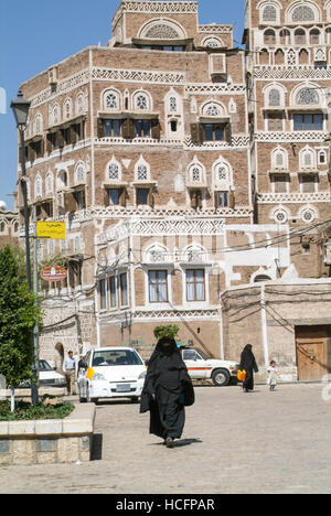 Sana, Jemen - 19. Januar 2008: Frauen tragen die Burka und zu Fuß vor der geschmückten Häuser des alten Sana, UNESCO-Welterbe Stockfoto