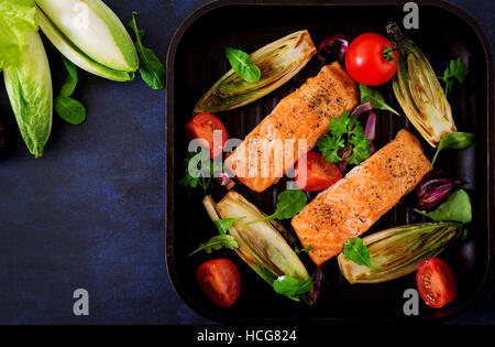 Gebackenen Lachs mit italienischen Kräutern und garniert mit Chicorée. Ansicht von oben. Stockfoto