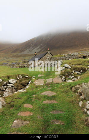 "Die Straße", ein Stein Weg gesäumt restaurierte historische Landhäuser, Teil einer alten verlassenen Siedlung auf St. Kilda, Schottland. Stockfoto