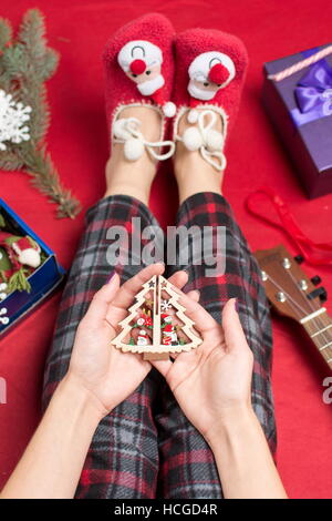 weibliche Hände halten eine Weihnachtsbaum-Spielzeug Stockfoto
