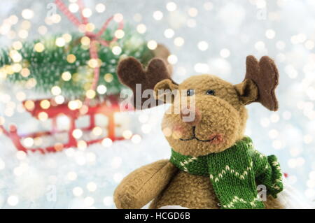 Spielzeug-Rentier und einen Weihnachtsbaum auf dem Schlitten mit Schnee bedeckt Stockfoto