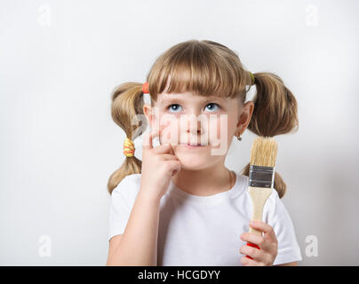 Kind spielt mit Pinsel und Farben Stockfoto