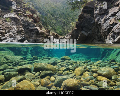 Felsen über und unter dem Wasser geteilt durch Wasserlinie in einem Fluss mit klarem Wasser, Dumbea Fluss, Neu-Kaledonien Stockfoto