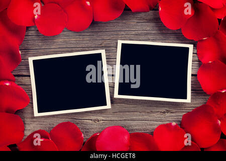 Valentinstag leere Bilderrahmen über hölzerne Hintergrund und rote Rosenblüten. Retro, getönt Stockfoto