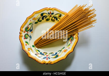 Ungekocht trocken Vollkorn Spaghetti in eine reich verzierte Italienische Schüssel Stockfoto