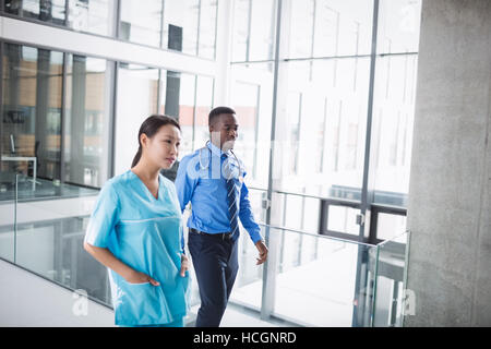 Arzt und Krankenschwester zu Fuß im Korridor Stockfoto