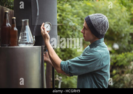 Mann prüfen Messen bei der Herstellung von Bier Stockfoto