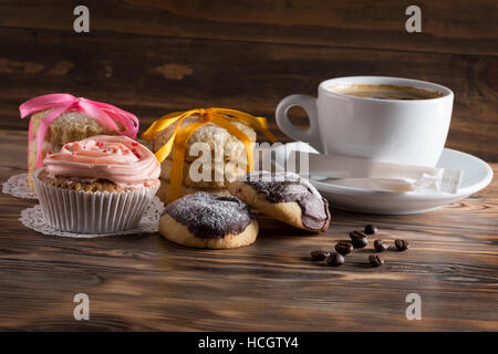 Tasse Kaffee mit Kuchen und Kekse auf einem hölzernen Hintergrund. Stockfoto