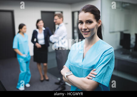 Lächelnd Krankenschwester stehend mit Arme gekreuzt Stockfoto