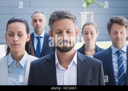 Gruppe von Geschäftsleuten mit geschlossenen Augen Stockfoto