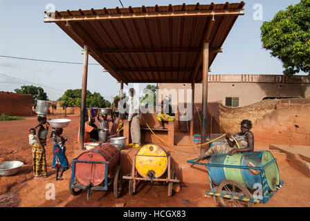 BURKINA FASO Banfora, Frauen und Kinder holen Trinkwasser aus dem Wasser verkaufen Bahnhof / BURKINA FASO Banfora, Frauen Und Kinder Holen Wasser von Einer Verkaufsstelle Stockfoto