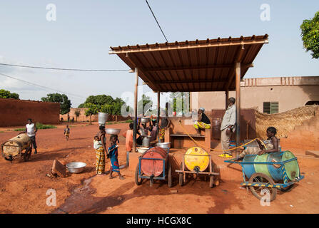 BURKINA FASO Banfora, Frauen und Kinder holen Trinkwasser aus dem Wasser verkaufen Bahnhof / BURKINA FASO Banfora, Frauen Und Kinder Holen Wasser von Einer Verkaufsstelle Stockfoto