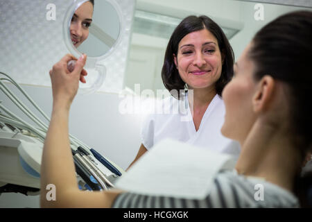 Patienten, die ihre Zähne im Spiegel überprüfen Stockfoto