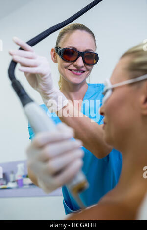 Frau, die Laser Epilation Behandlung auf die Schulter Stockfoto