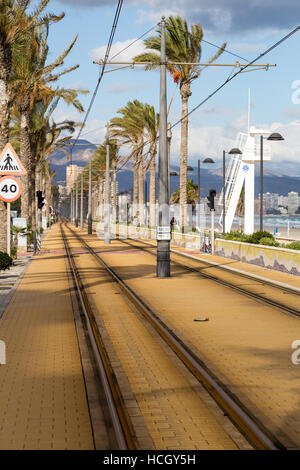 Playa de Muchavista, El Campello, Provinz Alicante, Spanien, Straßenbahn entlang der Strandpromenade an einem windigen Tag Stockfoto