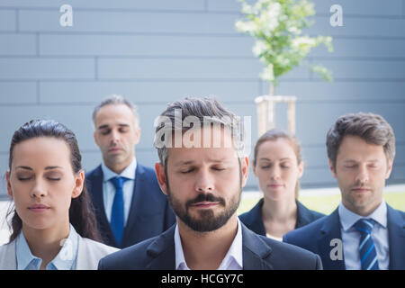 Gruppe von Geschäftsleuten mit geschlossenen Augen Stockfoto