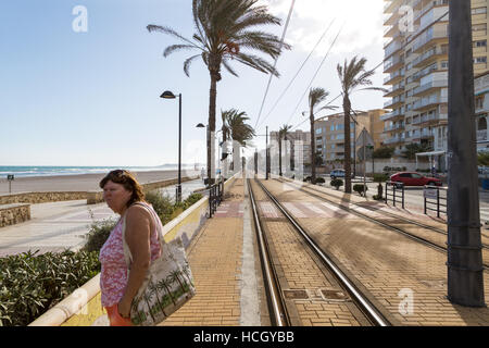 Playa de Muchavista, El Campello, Provinz Alicante, Spanien, Frau wartet für Straßenbahn Stockfoto