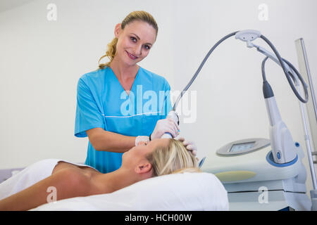 Frau, die Laser Epilation Behandlung auf der Stirn Stockfoto