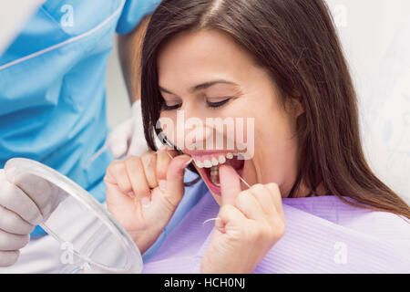 Patientin, die ihre Zähne Zahnseide Stockfoto