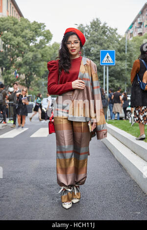 Frau mit rotem Hut und satin Jacke vor Giorgio Armani-Modenschau, Milan Fashion Week Streetstyle am 23. September 2016. Stockfoto