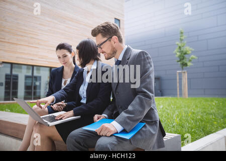 Geschäftsfrau mit Kollegen zu sitzen und mit laptop Stockfoto