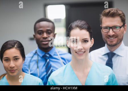 Ärzteteam stehen gemeinsam im Krankenhausflur lächelnd Stockfoto