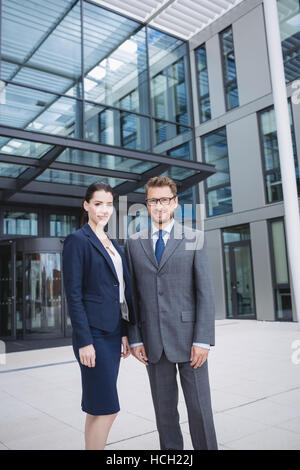 Zuversichtlich Geschäftsmann mit Kollegen stehen außen Bürogebäude Stockfoto