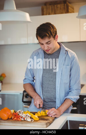 Mann Hacken Gemüse in der Küche Stockfoto