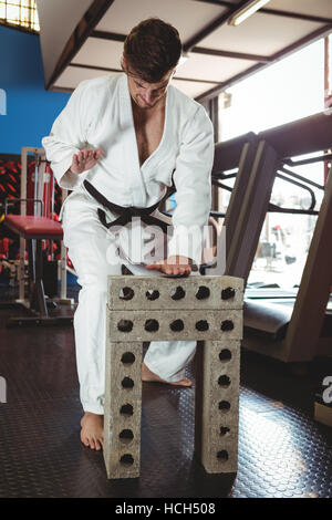 Karate Spieler brechen Betonblock Stockfoto