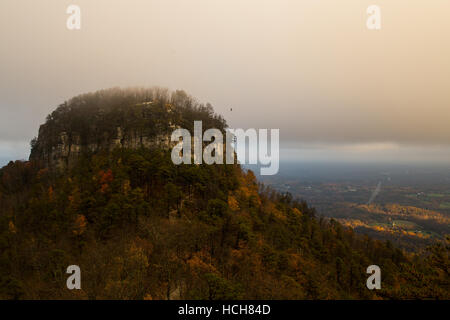 Großer Höhepunkt der Pilot Knob in North Carolina, USA, zeigt farbiges Herbstlaub und eine niedrige Wolkendecke mit Kreisen Vögel Stockfoto