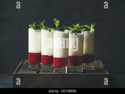 Catering, Bankett oder Party Food-Konzept. Dessert im Glas mit Brombeeren und Minze Blätter über dunklen Hintergrund auf Firmenfeier, Weihnachten, birthd Stockfoto