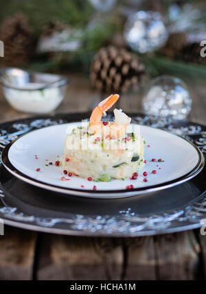 Garnelen und Zucchini Risotto auf Holztisch mit Weihnachtsschmuck Stockfoto