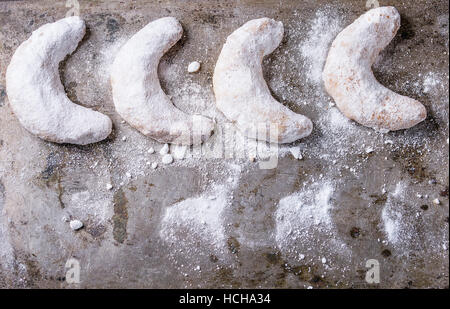 Hausgemachte Weihnachten Muttern Cookies Halbmond mit Zuckerpuder auf Vintage-Textur Metall Hintergrund. Ansicht von oben Platz für text Stockfoto