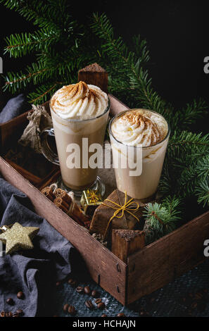 Kürbis würzig Latte mit Sahne und Zimt in zwei Gläser im Holzbrett mit Textil- und Dekoration und Tanne Weihnachtsbaum andere stehen Stockfoto