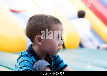 Trauriger kleiner Junge am Spielplatz Stockfoto