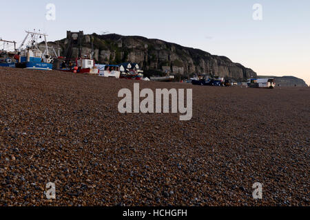 Blick auf Osthügel und Angelboote/Fischerboote am Strand bei Sonnenaufgang in Hastings Stockfoto