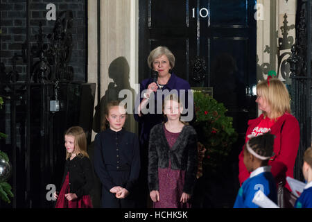 London, UK. 8. Dezember 2016. Theresa kann der britische Premierminister mit Kindern, die von britischen Wohltätigkeitsorganisationen und eine lokale Schulchor der Downing Street Weihnachtsbaum Lichter einschalten nominiert. Mit 3 Mädchen aus ihrem Wahlkreis gewonnen, die einen Wettbewerb zur Gestaltung dieser Jahre Weihnachtskarte für den Ministerpräsidenten. Bildnachweis: Alex MacNaughton/Alamy Live-Nachrichten Stockfoto