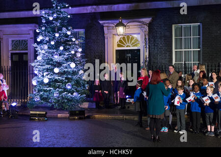 London, UK. 8. Dezember 2016. Theresa kann der britische Premierminister mit Kindern, die von britischen Wohltätigkeitsorganisationen und eine lokale Schulchor der Downing Street Weihnachtsbaum Lichter einschalten nominiert. Mit 3 Mädchen aus ihrem Wahlkreis gewonnen, die einen Wettbewerb zur Gestaltung dieser Jahre Weihnachtskarte für den Ministerpräsidenten. Bildnachweis: Alex MacNaughton/Alamy Live-Nachrichten Stockfoto