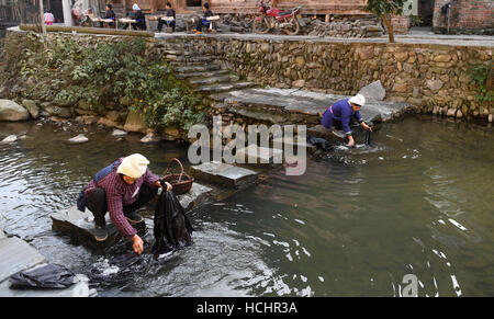 Rongjiang, Chinas Provinz Guizhou. 8. Dezember 2016. Dorfbewohner Wäsche am Fluss Dali Dong-Camp in Rongjiang County, Südwesten Chinas Provinz Guizhou, 8. Dezember 2016. Alten Gebäude in Dali Dong Camp, die alle mit Holzkonstruktionen der Zapfen- und verzapfen bestehen, wurden als wichtige Kulturdenkmal Einheit unter Staatsschutz 2013 aufgelistet. © Lu Boan/Xinhua/Alamy Live-Nachrichten Stockfoto