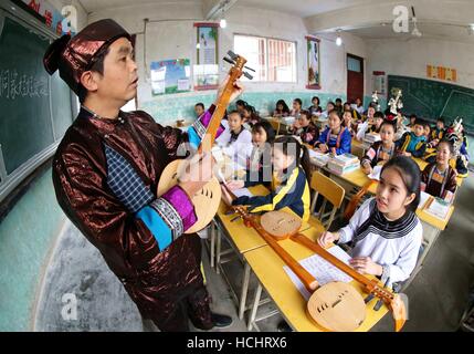 Rongjiang, Chinas Provinz Guizhou. 8. Dezember 2016. Ein Lehrer der Dong ethnische Gruppe lehrt die Fähigkeiten spielen Pipa, ein Volksinstrument in Chejiang Minzu Middle School in Rongjiang County, Südwesten Chinas Provinz Guizhou, 8. Dezember 2016. © Pan Jinqiang/Xinhua/Alamy Live-Nachrichten Stockfoto