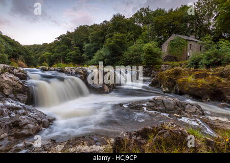 Eine alte Wassermühle befindet sich auf der anderen Seite des Flusses Teifi an den Cenarth Falls Stockfoto