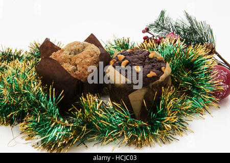 Weihnachten-Stilleben mit Ingwer-Honig-Muffins, Ornamente, Kiefer, Schuhe, Geschenk, Kränze Schokolade Süßigkeiten auf einem hölzernen Hintergrund Stockfoto