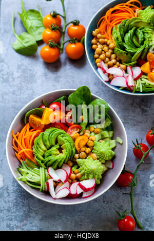 Buddha Gemüse Schüssel mit Avocado, Romanesco Blumenkohl, Karotten, Kichererbsen, Tomaten und Radieschen Stockfoto