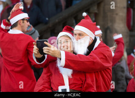 Paar verkleidet als Weihnachtsmann, wobei eine Selfie, Winchester, Hampshire, UK Stockfoto