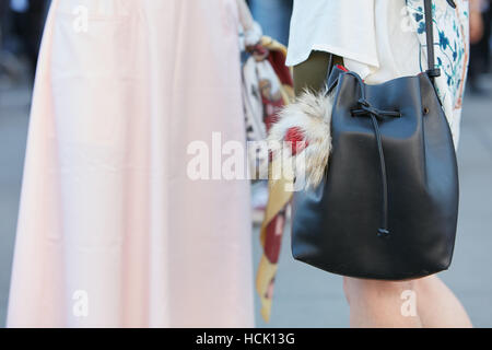 Frau mit schwarzem Ledertasche mit Fell Detail vor Jil Sander Fashion Show in Mailand Fashion Week Streetstyle am 24. September. Stockfoto