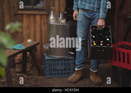 Mann mit Bierflaschen in Kiste Stockfoto