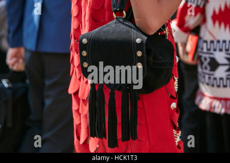 Frau mit rotem Kleid und V 73 schwarzer Rucksack mit Fransen vor Stella Jean Modenschau, Milan Fashion Week Streetstyle. Stockfoto