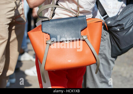 Frau mit orangenen und blauen Celine Tasche vor Stella Jean Modenschau, Milan Fashion Week Streetstyle am 25. September 2016. Stockfoto