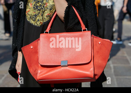 Frau mit orange Celine Tasche vor Stella Jean Modenschau, Milan Fashion Week Streetstyle am 25. September 2016 in Mailand. Stockfoto